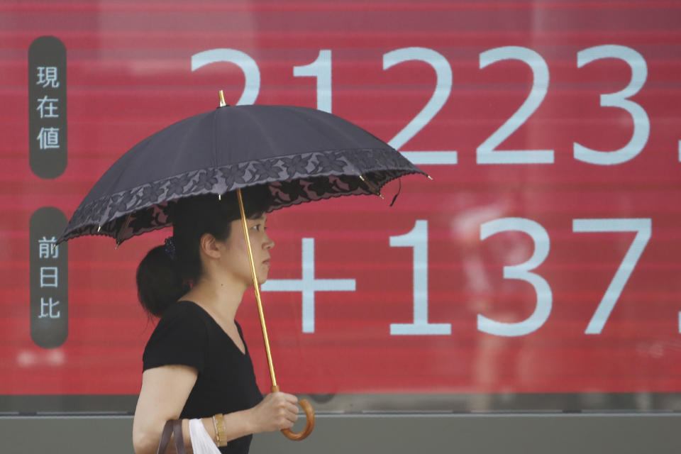 A woman walks by an electronic stock board of a securities firm in Tokyo, Friday, Sept. 6, 2019. Asian shares rose Friday as investors cheered plans for more trade negotiations between Washington and Beijing and drew encouragement from positive data about the U.S. economy. (AP Photo/Koji Sasahara)