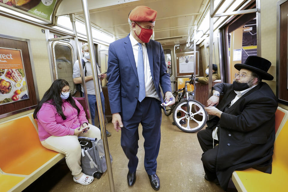 New York City Republican mayoral candidate Curtis Sliwa, center, talks to commuters while he rides the A train to get to a campaign event, Tuesday, Oct. 12, 2021, in New York. (AP Photo/Mary Altaffer)