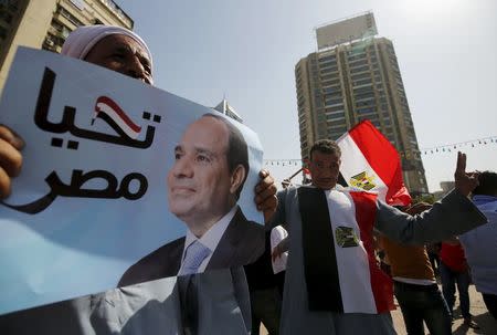 A supporter of Egypt's army and Egyptian President Abdel Fattah al-Sisi holds a poster with Sisi's picture during the anniversary of Sinai Liberation Day celebrations in Cairo, Egypt, April 25, 2016. REUTERS/Amr Abdallah Dalsh