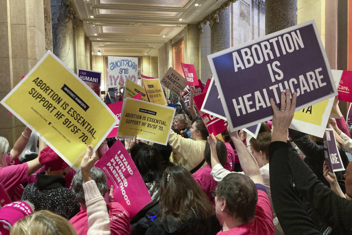 Abortion protesters on both sides pack the halls outside the Minnesota Senate chamber on Friday, Jan. 27, 2023, at the State Capitol in St. Paul, Minn. The Minnesota Senate is debating a bill Friday to write broad protections for abortion rights into state statutes, which would make it difficult for future courts to roll back. (AP Photo/Steve Karnowski)
