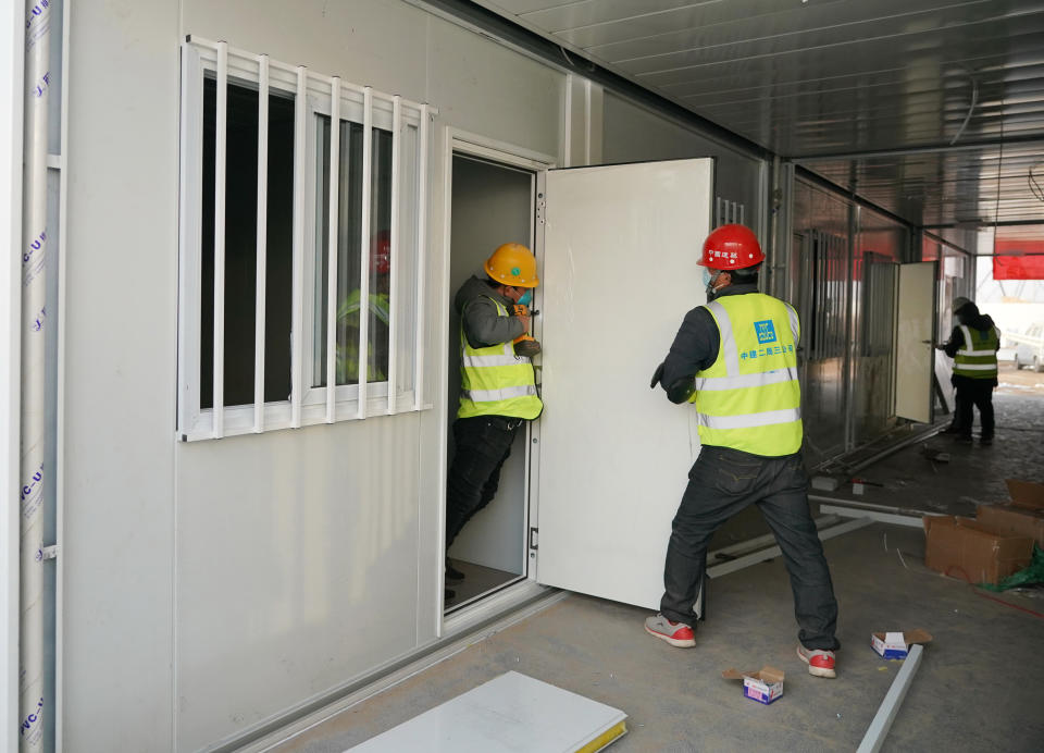 In this photo released by China's Xinhua News Agency, workers install doors at a large centralized quarantine facility capable of holding several thousand people in Shijiazhuang in northern China's Hebei Province, Saturday, Jan. 16, 2021. China on Saturday finished building a 1,500-room hospital for COVID-19 patients in Nangong, south of Beijing in Hebei Province, to fight a surge in infections the government said are harder to contain and that it blamed on infected people or goods from abroad. (Yang Shiyao/Xinhua via AP)