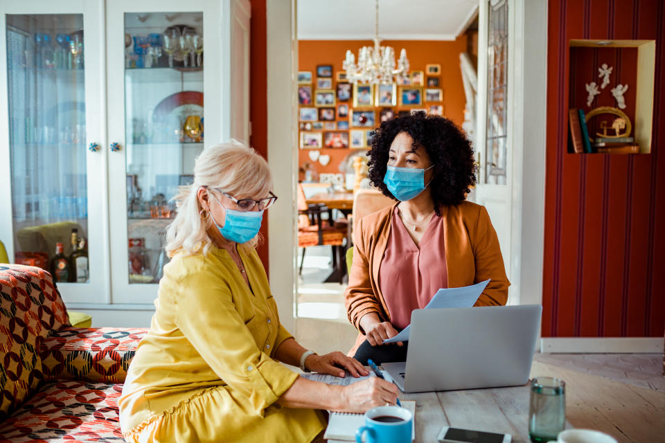 Close up of a woman getting investment help from a financial adviser. Both are wearing face masks.