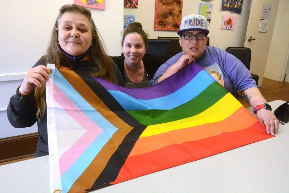 Mary Dolan Hinton, co-facilitator Gay Straight Alliance at Reliance Health, center, and clients Linda Maria Calabro of Taftville, left, and Dasya Butts of Norwich with the LGBTQ+ flag in downtown Norwich. They want to raise the flag at Norwich City Hall.