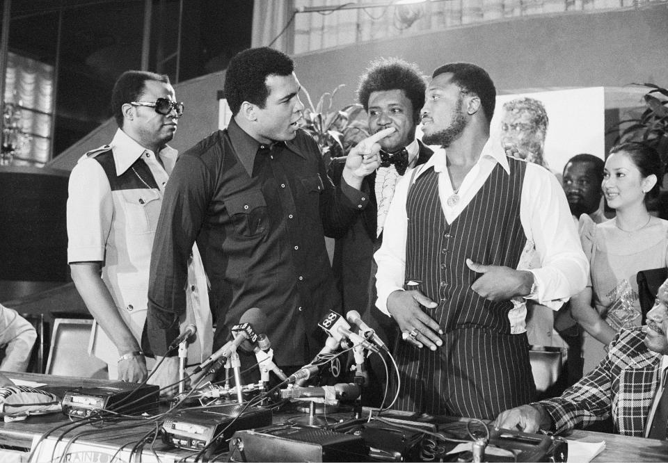 World heavyweight champion Muhammad Ali, left, points at challenger Joe Frazier at a news conference in New York City, Thursday, July 17, 1975.  Ali and Frazier will meet Oct. 1 in Manila in their third match-up title fight dubbed "Thrilla in Manila."  Standing between the fighters is boxing promoter Don King.