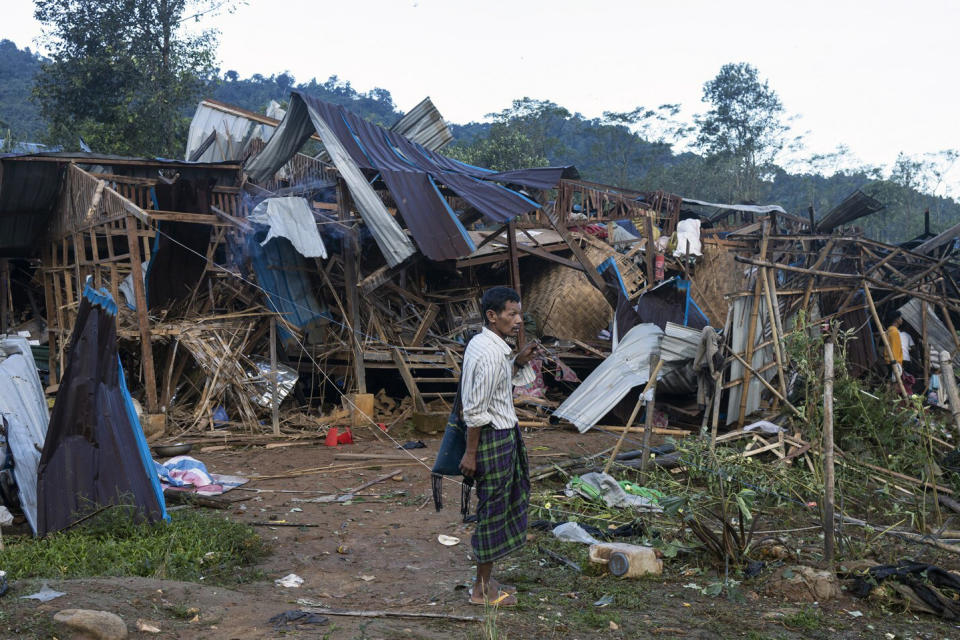 FILE - A man looks on at homes destroyed after air and artillery strikes in Mung Lai Hkyet displacement camp, in Laiza, Myanmar, on Oct. 10, 2023. When the army moved to overthrow Myanmar's elected government in the early hours of Feb. 1, 2021, to overthrow the elected government of Aung San Suu Kyi, it looked like a walkover that could entrench the military in power indefinitely. Three years later, a poorly armed but popular and politically savvy grassroots resistance movement has shaken the military’s grip, in a modern-day David vs. Goliath scenario, but the costs have been high. (AP Photo, File)