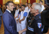 French President Emmanuel Macron, left, meets security and rescue forces in Annecy, French Alps, Friday, June 9, 2023. A man with a knife stabbed four young children at a lakeside park in the French Alps on Thursday June 8, 2023, assaulting at least one in a stroller repeatedly. Authorities said the children, between 22 months and 3 years old, suffered life-threatening injuries, and two adults were also wounded. (Denis Balibouse/Pool via AP)
