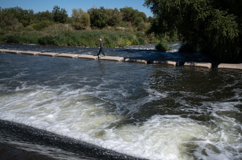 Bronson Mack crosses the Las Vegas Wash at Wetlands Park in Las Vegas on Sept. 26, 2022. The area's treated wastewater flows through the wash and back to Lake Mead, allowing the region to returning nearly half of its used water back to the source.