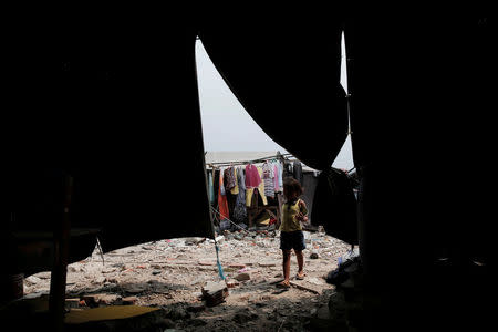 A child walks into a temporary shelter for people whose homes were demolished during eviction by the city authorities at Luar Batang district in Jakarta, Indonesia November 11, 2016. REUTERS/Beawiharta