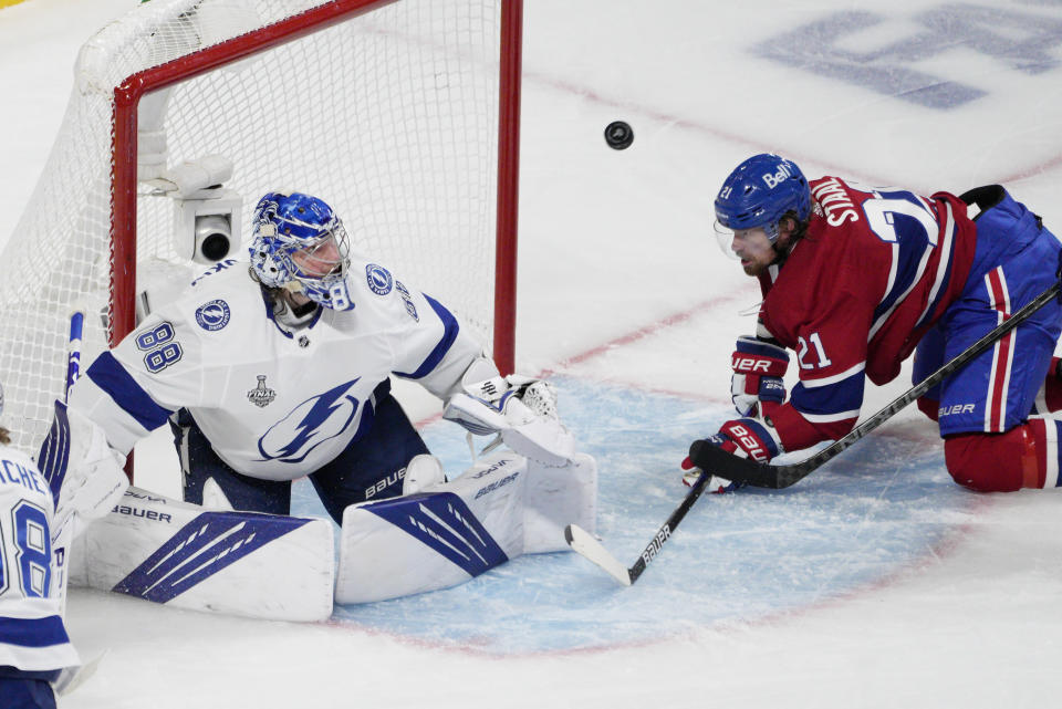 Tampa Bay Lightning goaltender Andrei Vasilevskiy (88) looks at the puck after making a save against Montreal Canadiens center Eric Staal (21) during the second period of Game 4 of the NHL hockey Stanley Cup final in Montreal, Monday, July 5, 2021. (Paul Chiasson/The Canadian Press via AP)