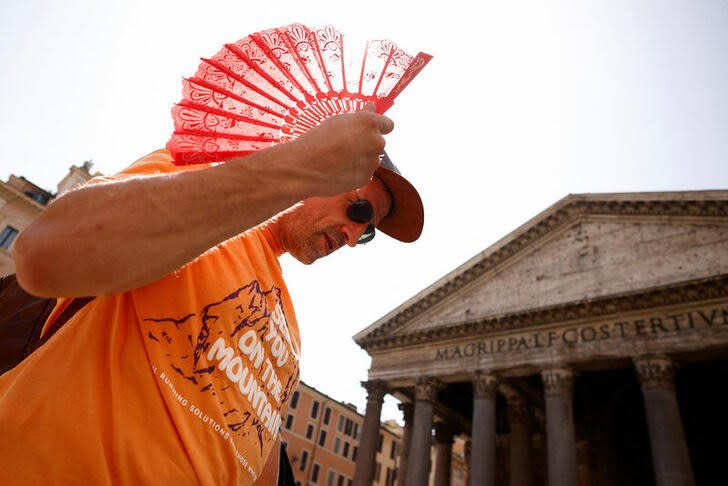 Una persona se refresca con un abanico mientras hace cola para entrar al Panteón en Roma, Italia.