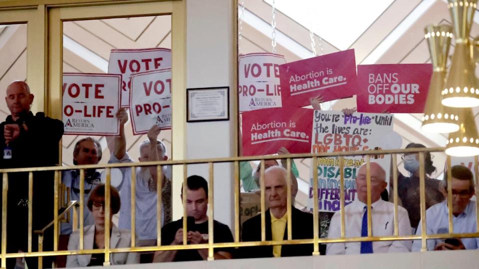 Protesters on both sides of the issue hold signs as North Carolina House members debate abortion access on May 16, 2023 (Associated Press)