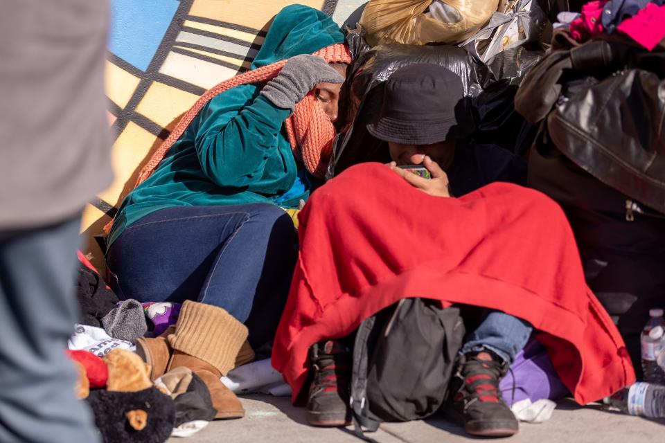 Venezuelan migrants bundle up to stay warm in the streets of El Paso in front of Sacred Heart Church, on Wednesday, Dec. 21, 2022, after crossing into the U.S.