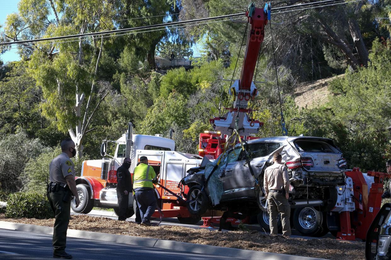 A crane is used to lift a vehicle following a rollover accident involving golfer Tiger Woods, Tuesday, Feb. 23, 2021, in the Rancho Palos Verdes section of Los Angeles.