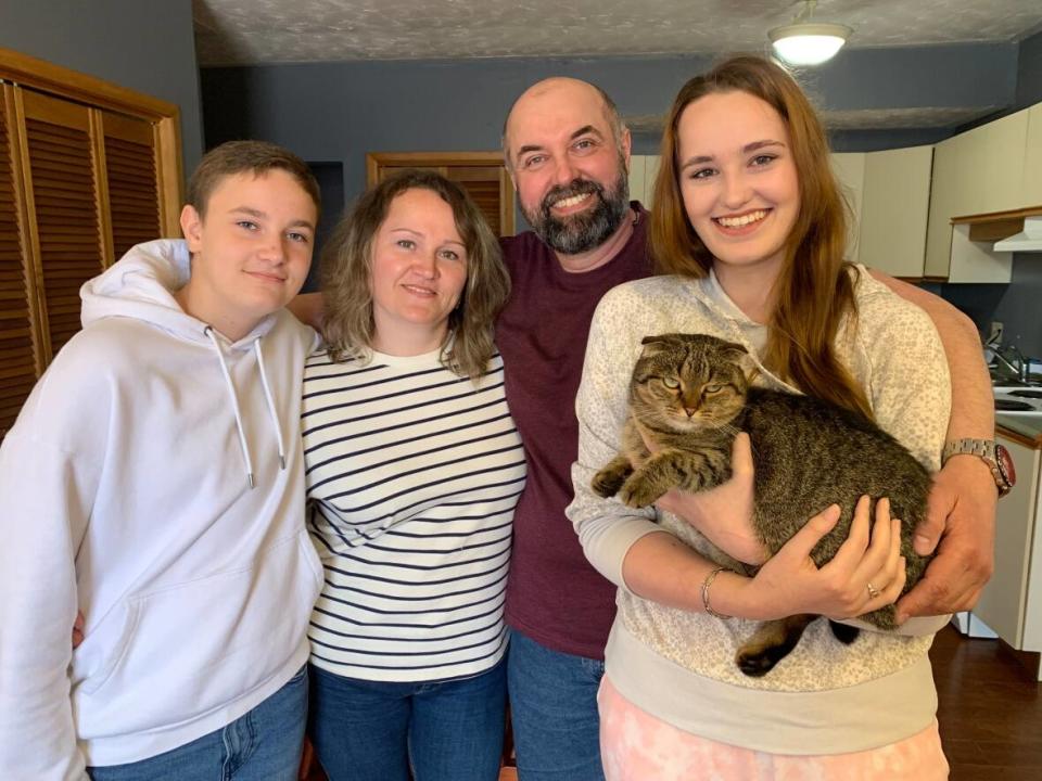 Anatolii Merdukh, centre, is pictured at home in P.E.I. with his wife Oksana; 16-year-old daughter Diana; 13-year-old son Arsenii and their cat Mikki. (Laura Meader/CBC - image credit)