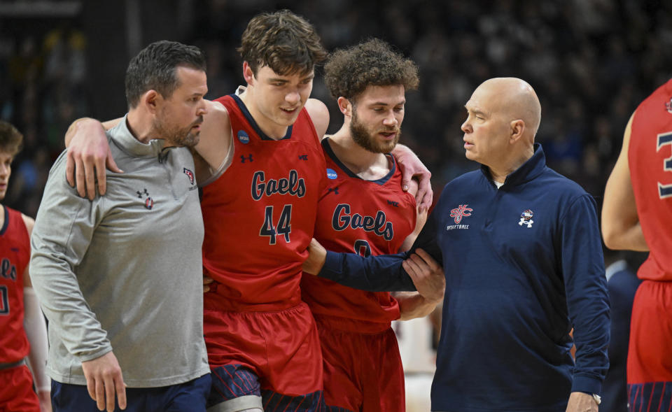 Saint Mary's guard Alex Ducas (44) is helped by teammates and coach Randy Bennett during the first half of the team's second-round college basketball game against UConn in the men's NCAA Tournamenton Sunday, March 19, 2023, in Albany, N.Y. (AP Photo/Hans Pennink)