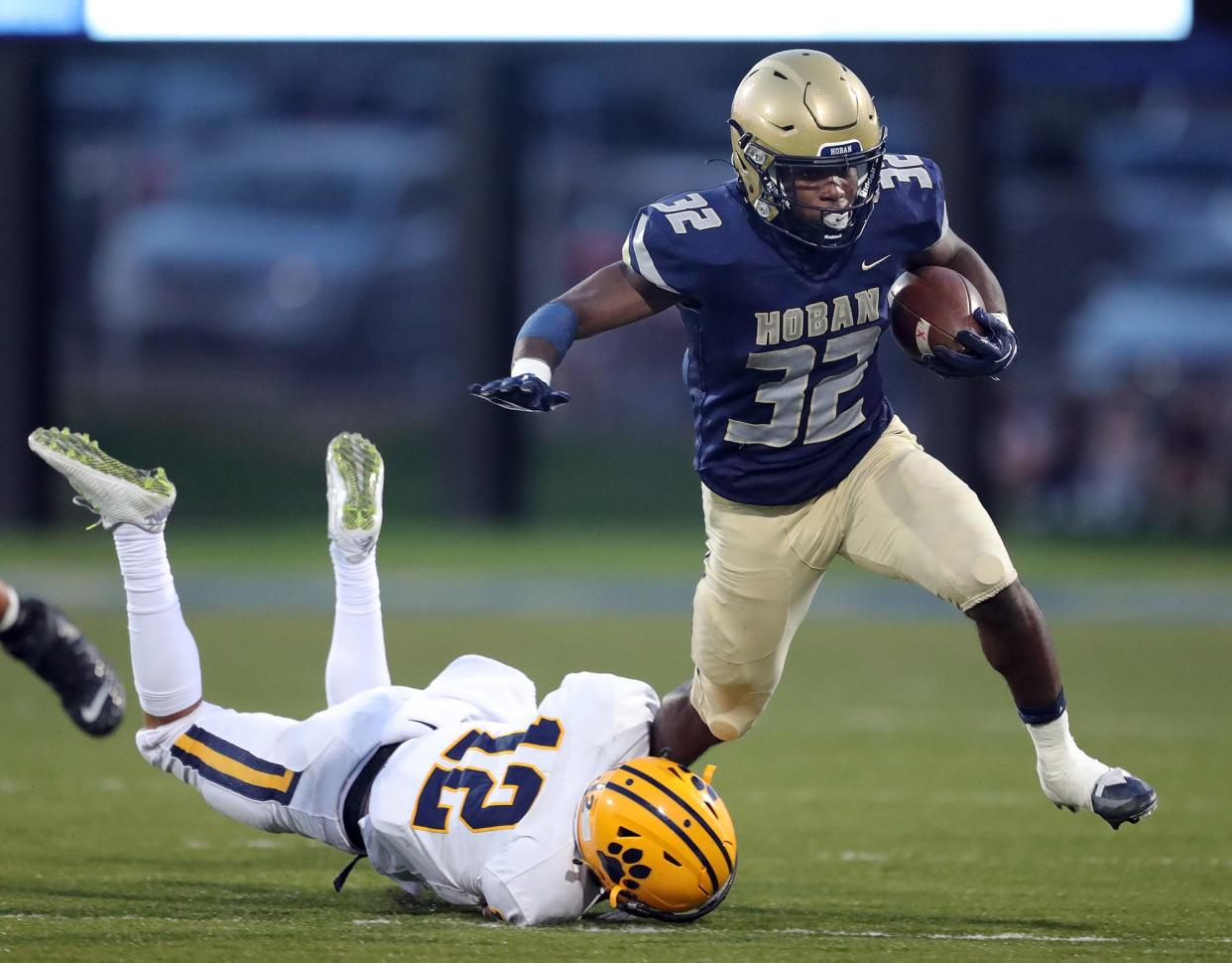 Hoban running back Lamar Sperling, top, escapes a tackle from St. Ignatius defensive back Cody Haddad during the first half of a high school football game, Friday, Sept. 16, 2022, in Akron, Ohio.