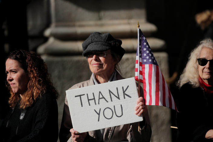 A woman holds a sign as she watches the Veterans Day parade in New York on Nov. 11, 2019. (Photo: Brendan McDermid/Reuters)