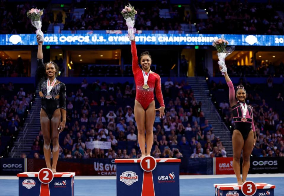 (From left) Shilese Jones, Konnor McClain and Jordan Chiles celebrate winning the all-around competition during the 2022 U.S. Gymnastics Championships at Amalie Arena on Aug. 21, 2022, in Tampa, Florida. (Photo by Mike Ehrmann/Getty Images)