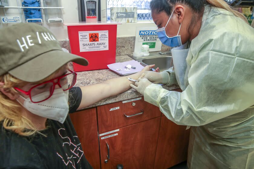 Los Angeles, CA - August 10: Jacquelyn Cano, a medical assistant, right, administers a Monkeypox virus vaccine to Orion Queer at St.John's Well Child & Family Center on Wednesday, Aug. 10, 2022 in Los Angeles, CA. (Irfan Khan / Los Angeles Times)