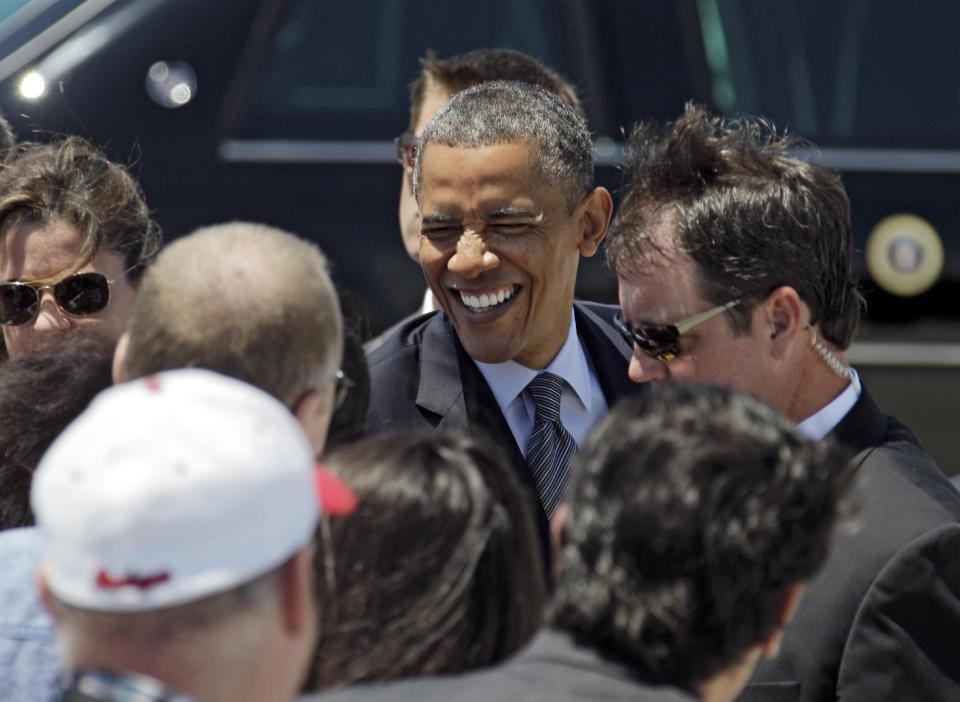 President Barack Obama greets supporters after arriving at Cleveland Hopkins International airport in Cleveland, Thursday, June 14, 2012, before attending a campaign event in the city. (AP Photo/Mark Duncan)