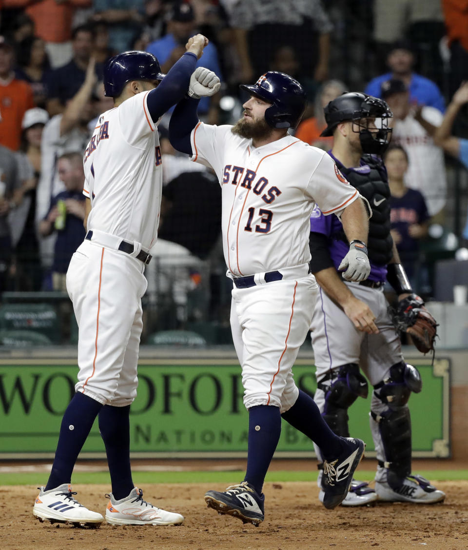 Houston Astros' Tyler White (13) celebrates with Carlos Correa after both scored on White's home run against the Colorado Rockies during the seventh inning of a baseball game Wednesday, Aug. 15, 2018, in Houston. (AP Photo/David J. Phillip)