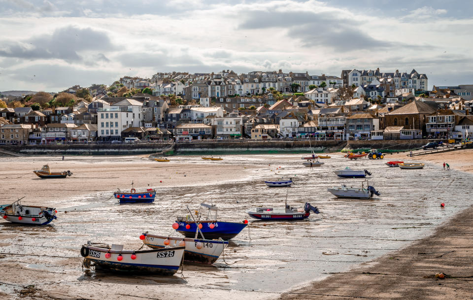 St Ives, Cornwall, England. The beach with boats at low tide, with the town in the background.