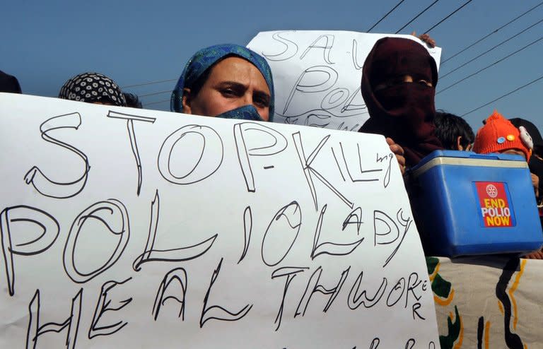 Pakistani polio vaccination workers carry placards during a protest against the killing of their colleagues in Lahore on December 21, 2012. Pakistan is providing paramilitary and police support to polio vaccinations being resumed discreetly in the northwest after a series of attacks on medical workers, officials said Friday