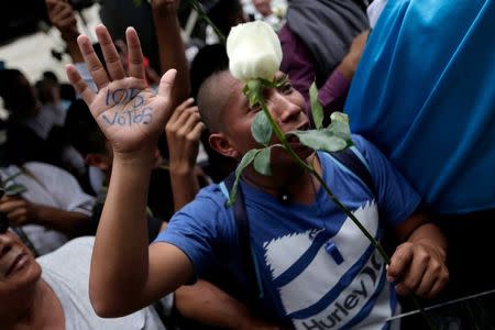 A demonstrator shows off his marked hand reading "105 votes", referring to the two-thirds majority of Congress needed to strip Guatemalan President Otto Perez Molina of his presidential immunity, outside the Congress in Guatemala City, September 1, 2015. REUTERS/Jorge Dan Lopez