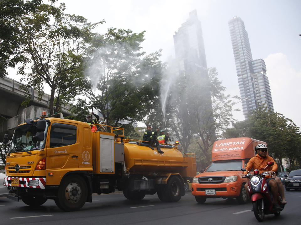 Bangkok toad crews spray water in hopes to control some of the smog in Bangkok, Thailand, Monday, Jan. 14, 2019. Unusually high levels of smog worsened by weather patterns are raising alarm across Asia. (AP Photo/Sakchai Lalit)