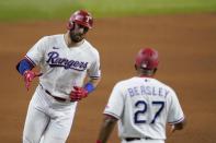 Texas Rangers' Joey Gallo, left, celebrates with third base coach Tony Beasley (27) after hitting a three-run home run off of Arizona Diamondbacks' Taylor Widener during the fourth inning of a baseball game in Arlington, Texas, Tuesday, July 27, 2021. (AP Photo/Tony Gutierrez)