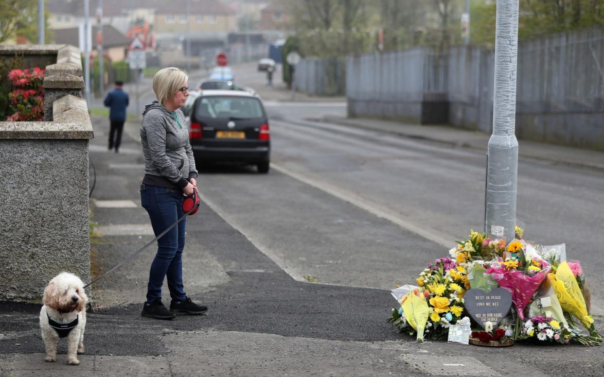 A woman stops to pay her respects at the scene on Fanad Drive, Londonderry, where 29-year-old journalist Lyra McKee was shot - PA