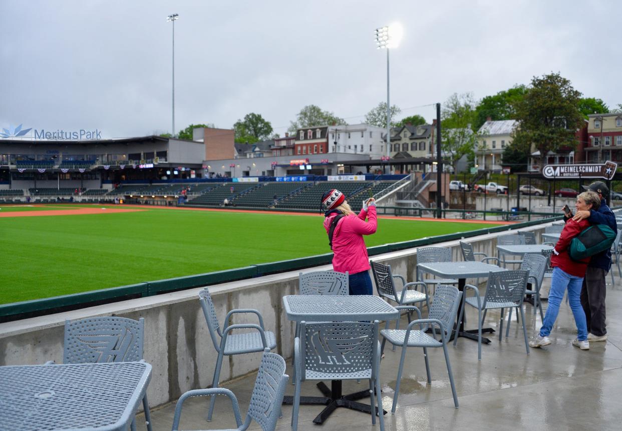 Kelsi Palmer takes a photo of her parents, Mary Ellen and Chuck Waltemire, in the elevated picnic area behind left field at Meritus Park before the start of the Hagerstown Flying Boxcars' inaugural home game on May 4, 2024.