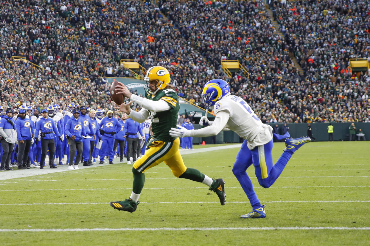 Green Bay Packers quarterback Aaron Rodgers (12) runs to score a touchdown against Los Angeles Rams cornerback Jalen Ramsey (5) during the first half of an NFL football game, Sunday, Nov. 27, 2021, in Green Bay, Wis. (AP Photo/Kamil Krzaczynski)