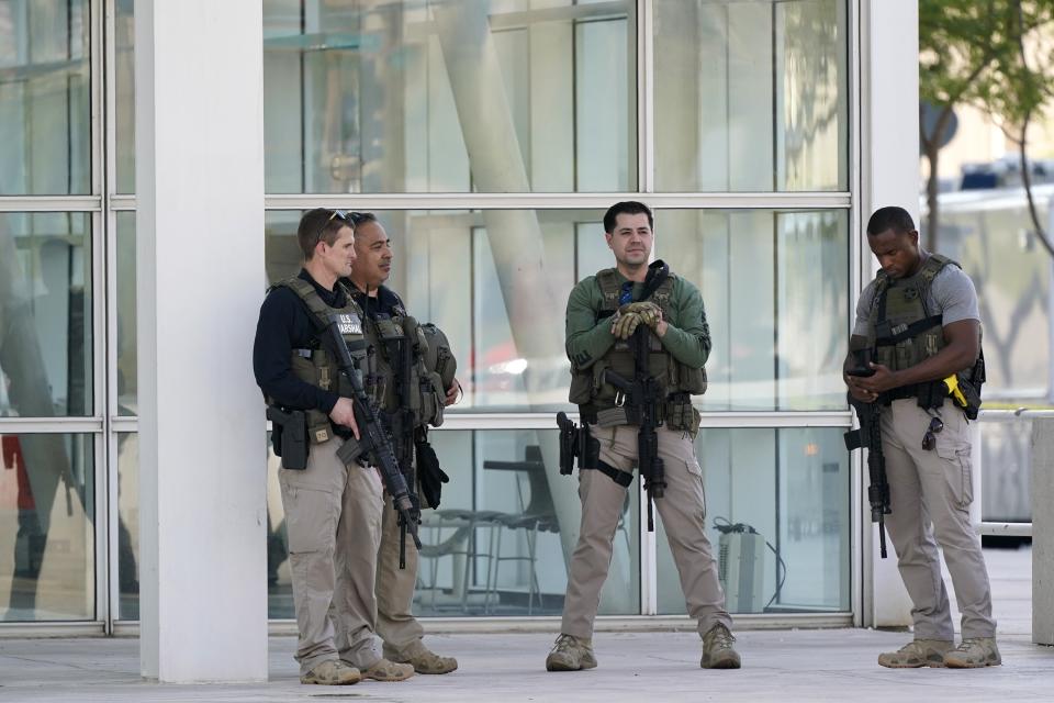 Federal law enforcement personnel stand outside the Sandra Day O'Connor Federal Courthouse Tuesday, Sept. 15, 2020, in Phoenix. A drive-by shooting wounded a federal court security officer Tuesday outside the courthouse in downtown Phoenix, authorities said. The officer was taken to a hospital and is expected to recover, according to city police and the FBI, which is investigating. (AP Photo/Ross D. Franklin)