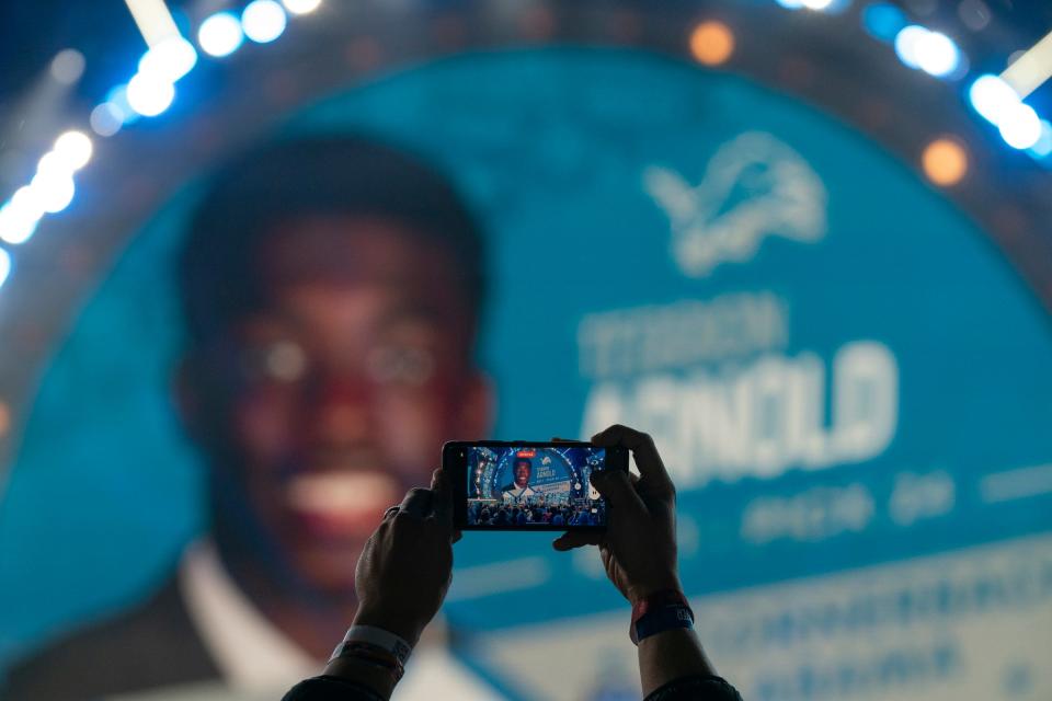 A fan uses their phone as Terrion Arnold, from Alabama, is announced as the Lions 24th pick in the draft in the main theater on Thursday, April 25, 2024 for the first day of the NFL Draft in Detroit.