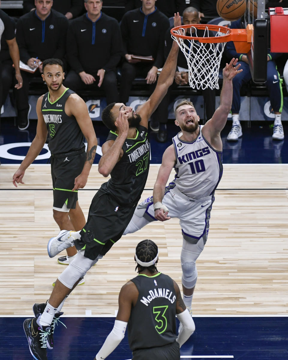 Sacramento Kings center Domantas Sabonis (10) goes up for a shot past Minnesota Timberwolves center Rudy Gobert (27) as forwards Kyle Anderson (5) and Jaden McDaniels (5) watch during the second half of an NBA basketball game Saturday, Jan. 28, 2023, in Minneapolis. The Timberwolves won 117-110. (AP Photo/Craig Lassig)