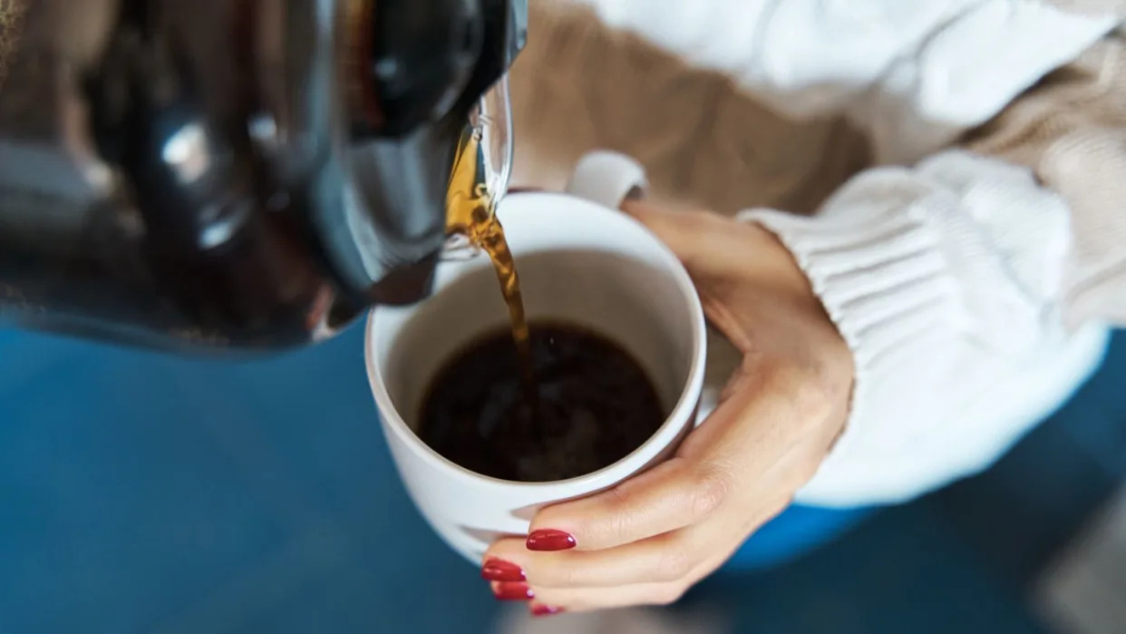 woman pouring herself hot coffee to a mug