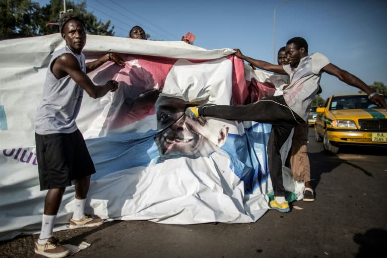 A supporter of the newly elected Gambia President Adama Barrow kicks a poster of the exiting leader Yahya Jammeh in Serekunda