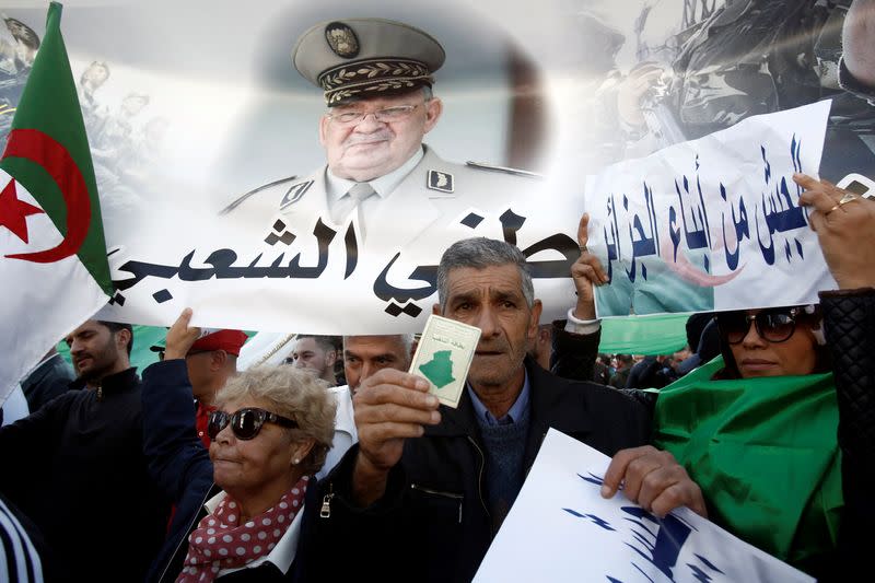 Pro-government supporters carry banners during a demonstration in Algiers