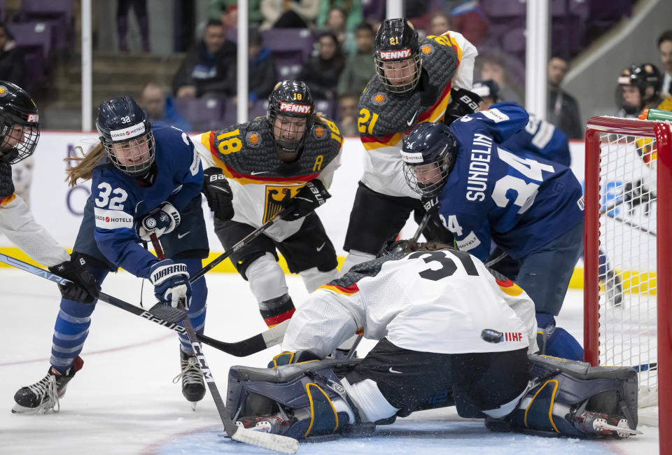 Finland forward Emilia Vesa (32) scores against Germany goaltender Johanna May (31) as Germany forward Bernadette Karpf (18) and defender Tabea Botthof (21) with Finland forward Sofianna Sundelin (34) look on during the first period of a match at the Women's World Hockey Championships in Brampton, Ontario, Friday, April 7, 2023. (Frank Gunn/The Canadian Press via AP)