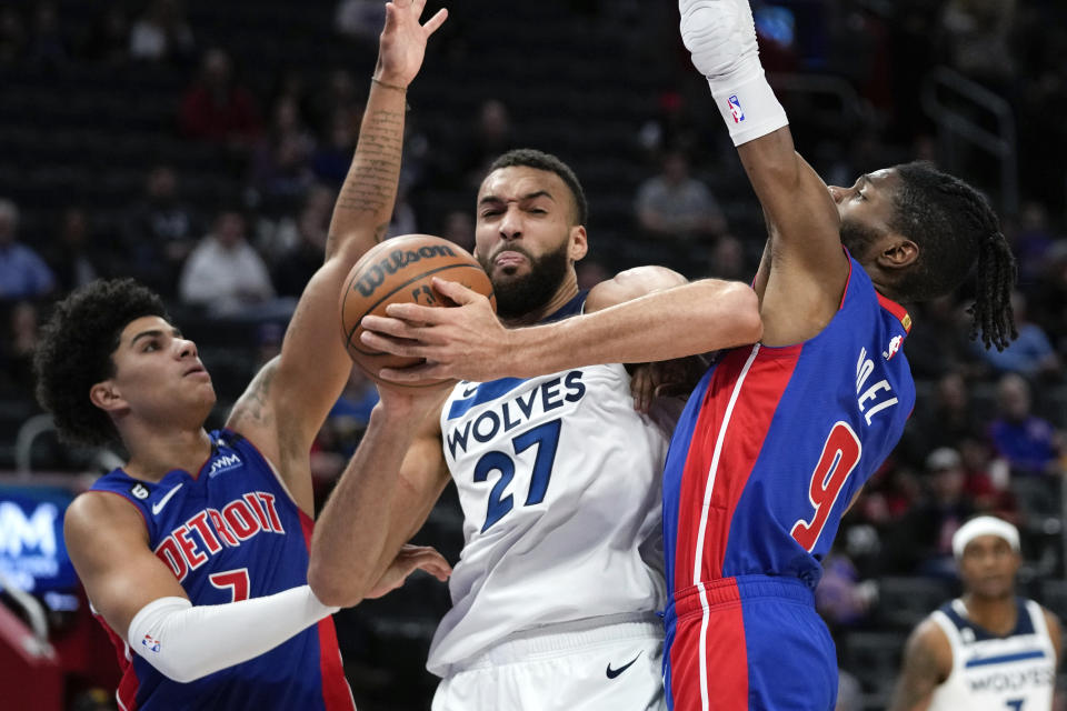 Minnesota Timberwolves center Rudy Gobert (27) tries to shoot between Detroit Pistons guard Killian Hayes (7) and Nerlens Noel (9) in the second half of an NBA basketball game in Detroit, Wednesday, Jan. 11, 2023. (AP Photo/Paul Sancya)