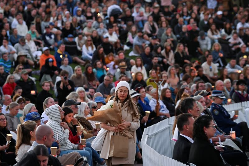 People gather for a candlelight vigil on Bondi Beach to pay respects to the victims of a fatal stabbing attack at a shopping centre in Sydney