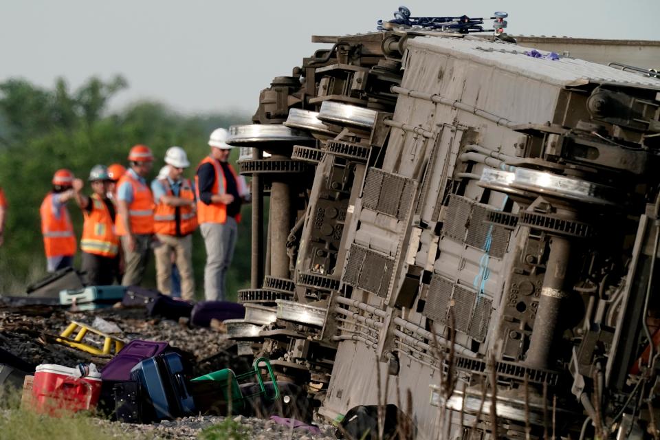 Workers inspect the scene of an Amtrak train that derailed after striking a dump truck June 27 near Mendon, Missouri.