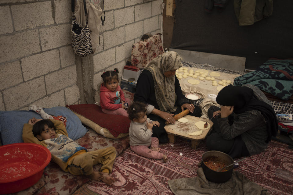 Palestinians displaced by the Israeli ground offensive on the Gaza Strip cook at the makeshift tent camp in Rafah on Tuesday, Jan. 23, 2024. (AP Photo/Fatima Shbair)