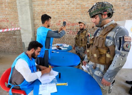 Afghan policemen arrive to cast their votes in presidential election in Jalalabad, Afghanistan