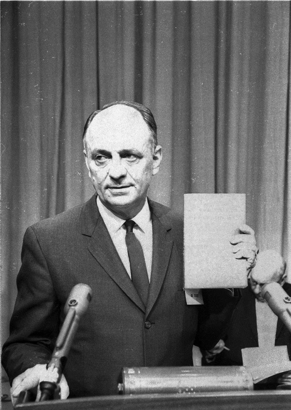 U.S. Surgeon General Luther Terry holds a copy of the 387 page report of the Advisory Committe to the Surgeon General of the Public Health Service on the relationship of smoking to health Jan. 11, 1964. He spoke at a Washington news conference at which the study was released. It termed smoking a health hazard calling for corrective action. (AP Photo/hwg)