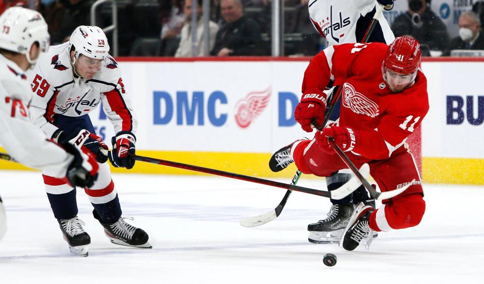 Red Wings right wing Filip Zadina gets tangled on the stick of Capitals center Aliaksei Protas during the third period of the Wings&#39; 3-1 loss on Friday, Dec. 31, 2021, at Little Caesars Arena.