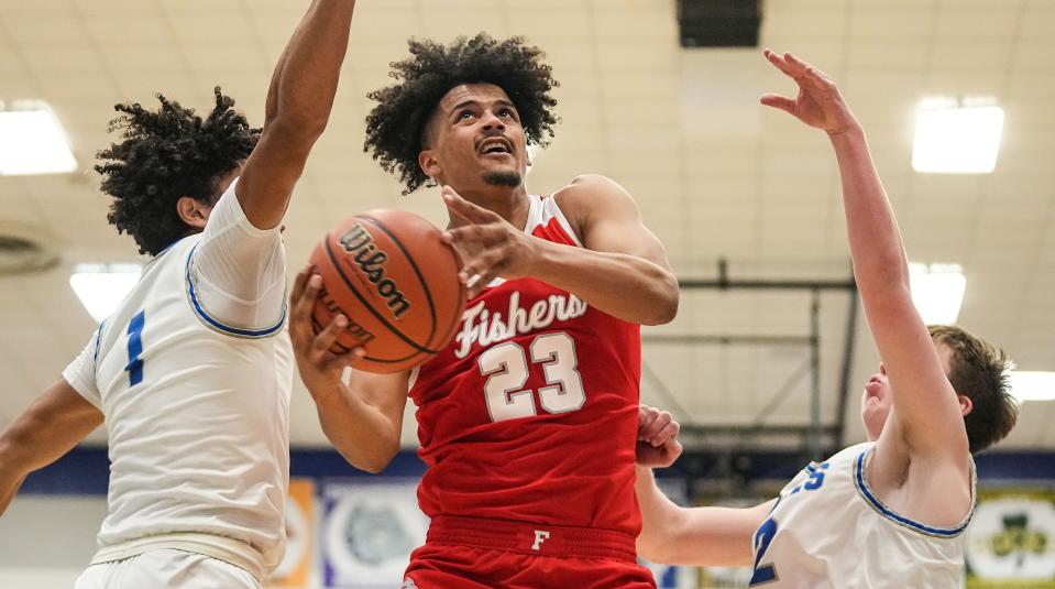 Fishers Tigers forward Keenan Garner (23) attempts to score against Hamilton Southeastern Royals Donovan Hamilton (1) on Friday, Dec. 15, 2023, during the game at Hamilton Southeastern High School in Fishers. The Fishers Tigers defeated the Hamilton Southeastern Royals, 64-57.