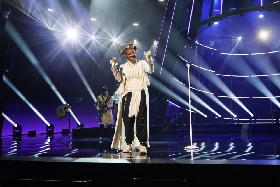 Brandy performs in lacey white shirt and black harem pants.