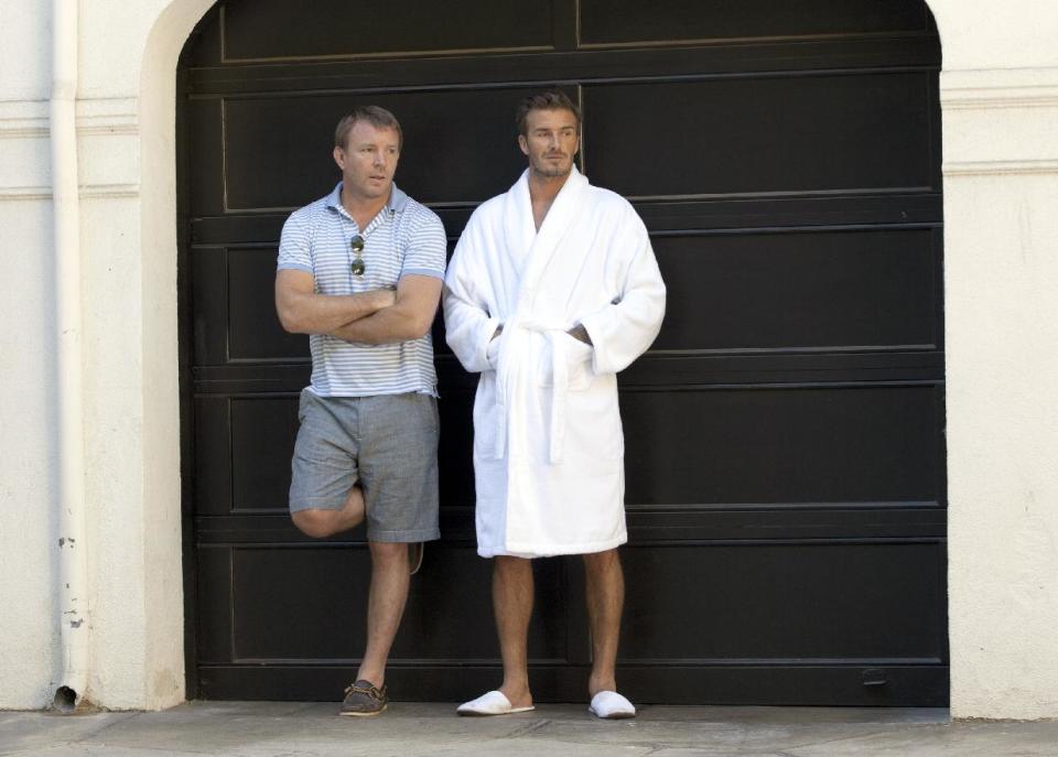 This October 2012 photo released by H & M shows soccer star David Beckham, right, and director Guy Ritchie on the set of Beckham's newest ad campaign for his bodywear collection in Los Angeles. The ad is more like a film short, directed by Guy Ritchie. Beckham stars as an action hero, saving the day in Los Angeles in his boxer briefs and bedroom slippers. (AP Photo/H&M)